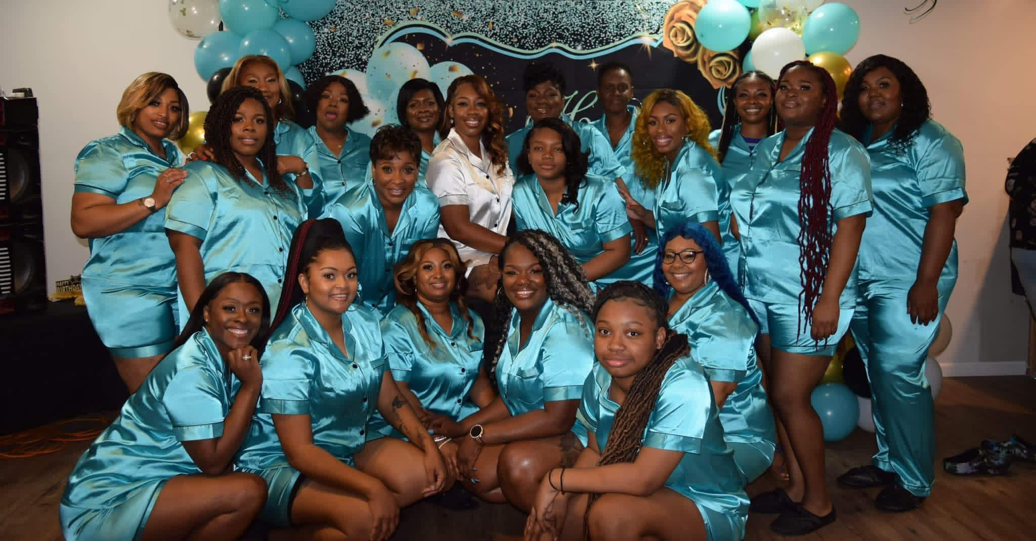 A sisterhood gathering in matching teal satin sets.
